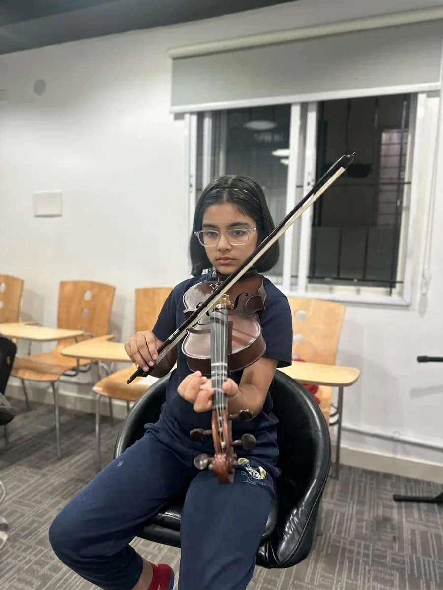 A student practising violin with a bow
